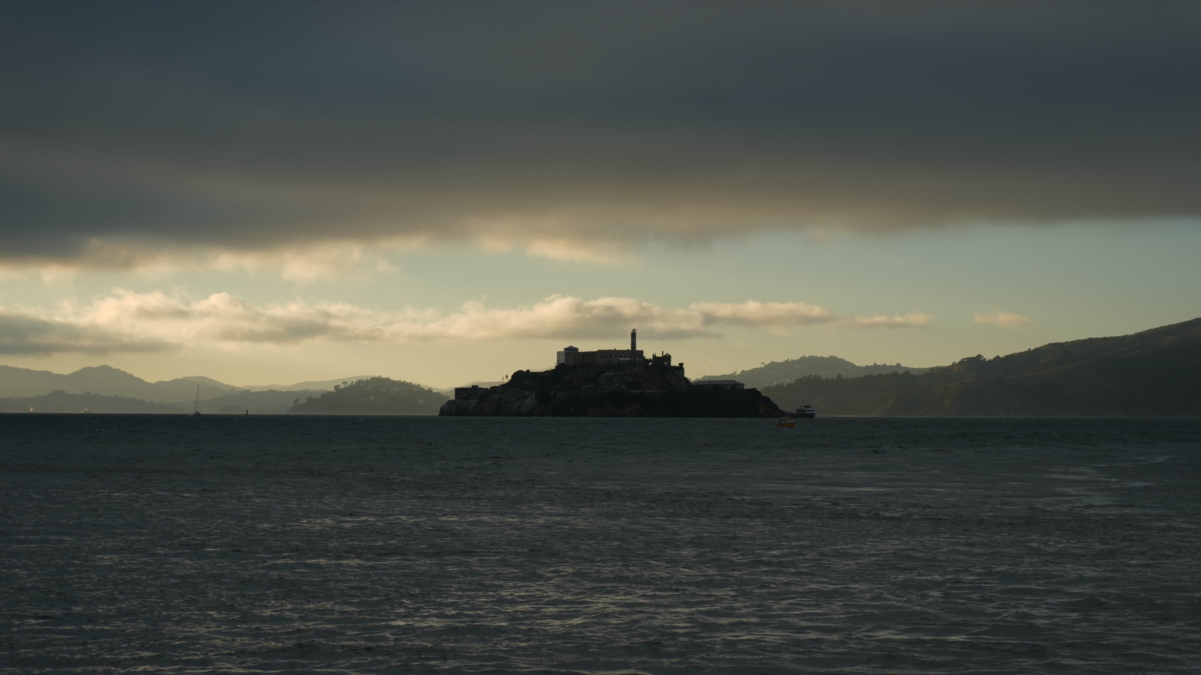 Alcatraz island silhouetted under a heavy cloud bank