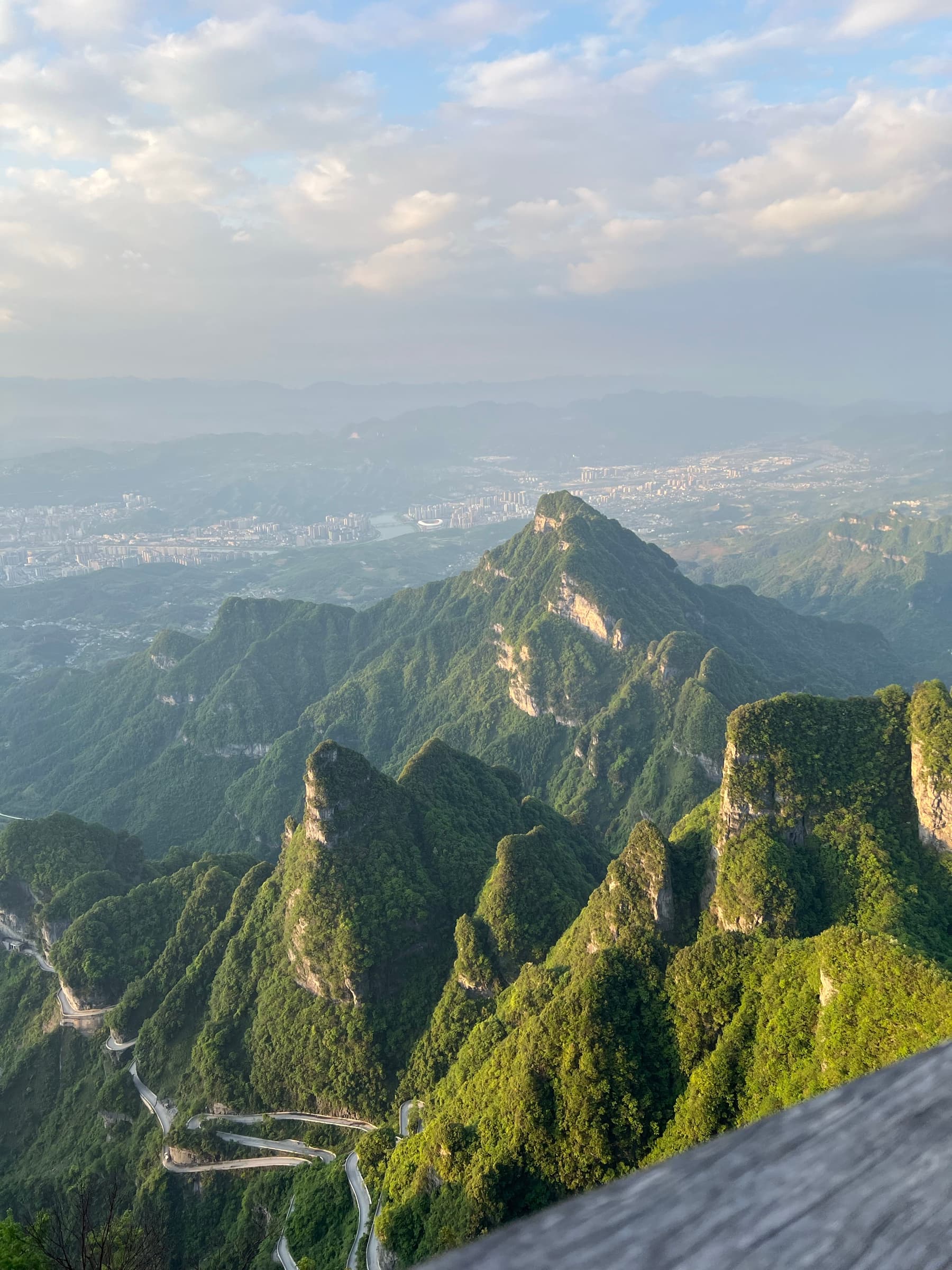 Switchback road winding up the green cliffs of Tianmen Mountain